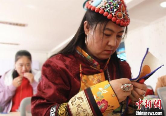 圖為裕固族婦女學(xué)習(xí)刺繡?！∈缝o靜 攝