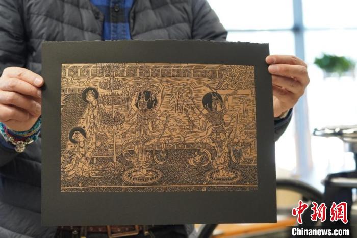 圖為手工書藝人展示敦煌雕版壁畫印刷品?！【琶赖┰?　攝