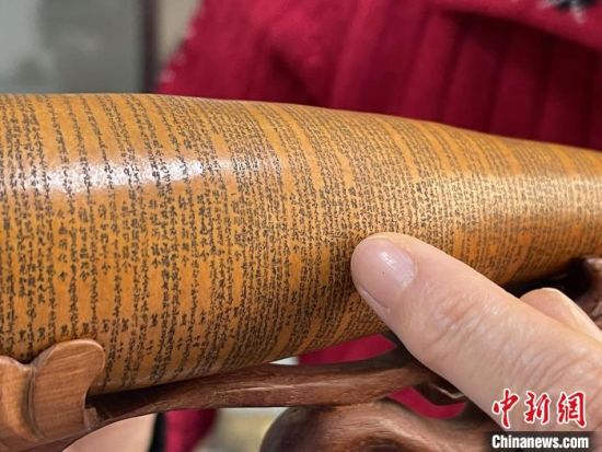 圖為長(zhǎng)約二十公分的長(zhǎng)條葫蘆雕刻佛教經(jīng)文作品?！堟?攝