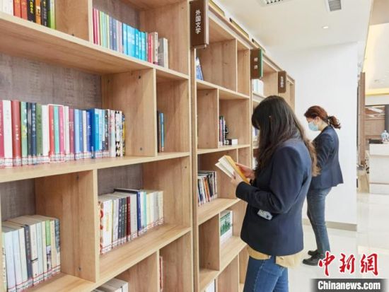 圖為在甘肅公航旅建設(shè)集團有限公司的職工書屋，職工挑選書籍?！⌒煅?攝