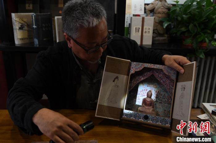 圖為讀者出版集團讀者晉林工作室獨立出品人徐晉林，展示互動性強的敦煌題材手工書。(資料圖) 楊艷敏 攝