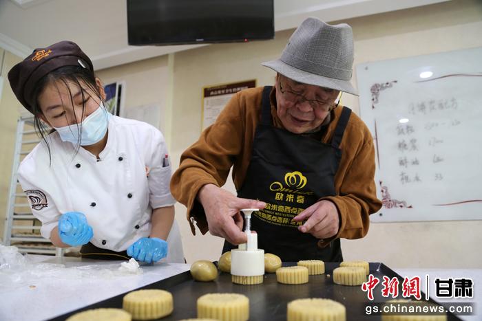 當(dāng)日，受邀參加活動的臺胞臺屬代表、兩岸婚姻及子女、在甘臺商代表等歡聚一堂。圖為77歲的在甘臺胞潘天鑒制作月餅。九美旦增 攝